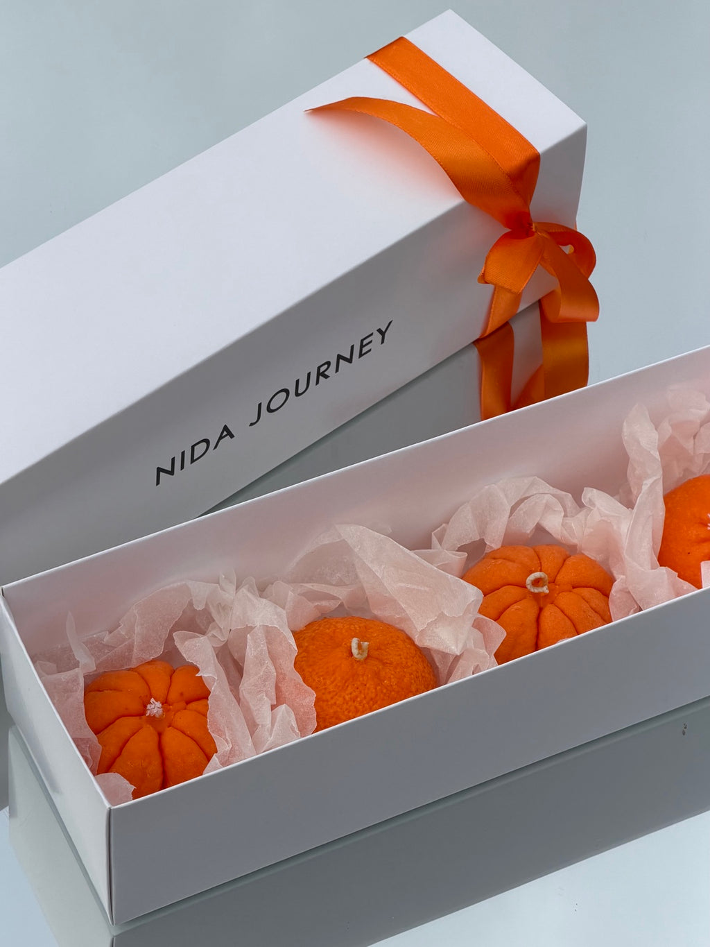 MANDARIN GIFT BOX — four mandarin candles in a white Nida Journey gift box